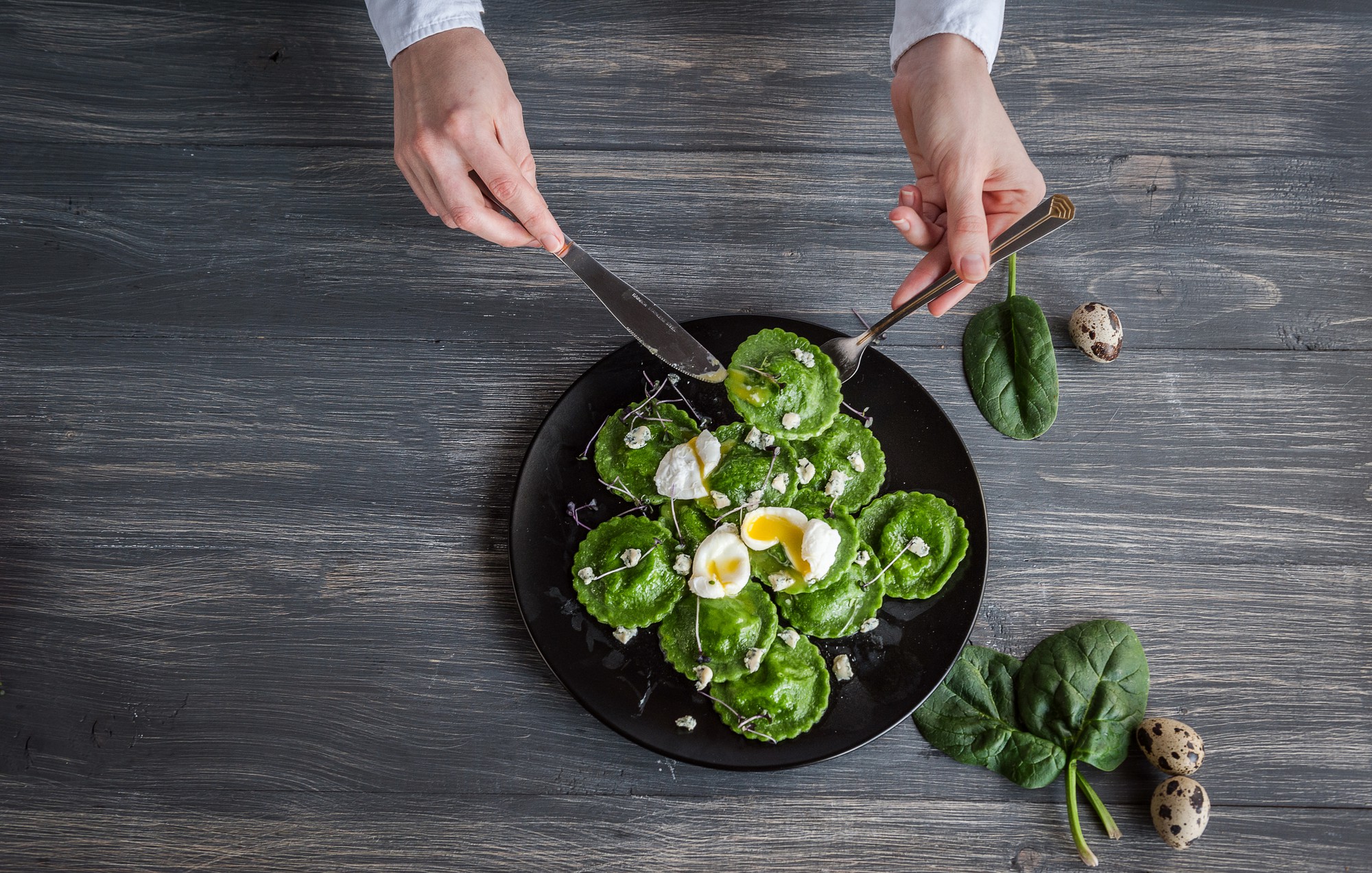 Chef preparing a plated dish on wooden table